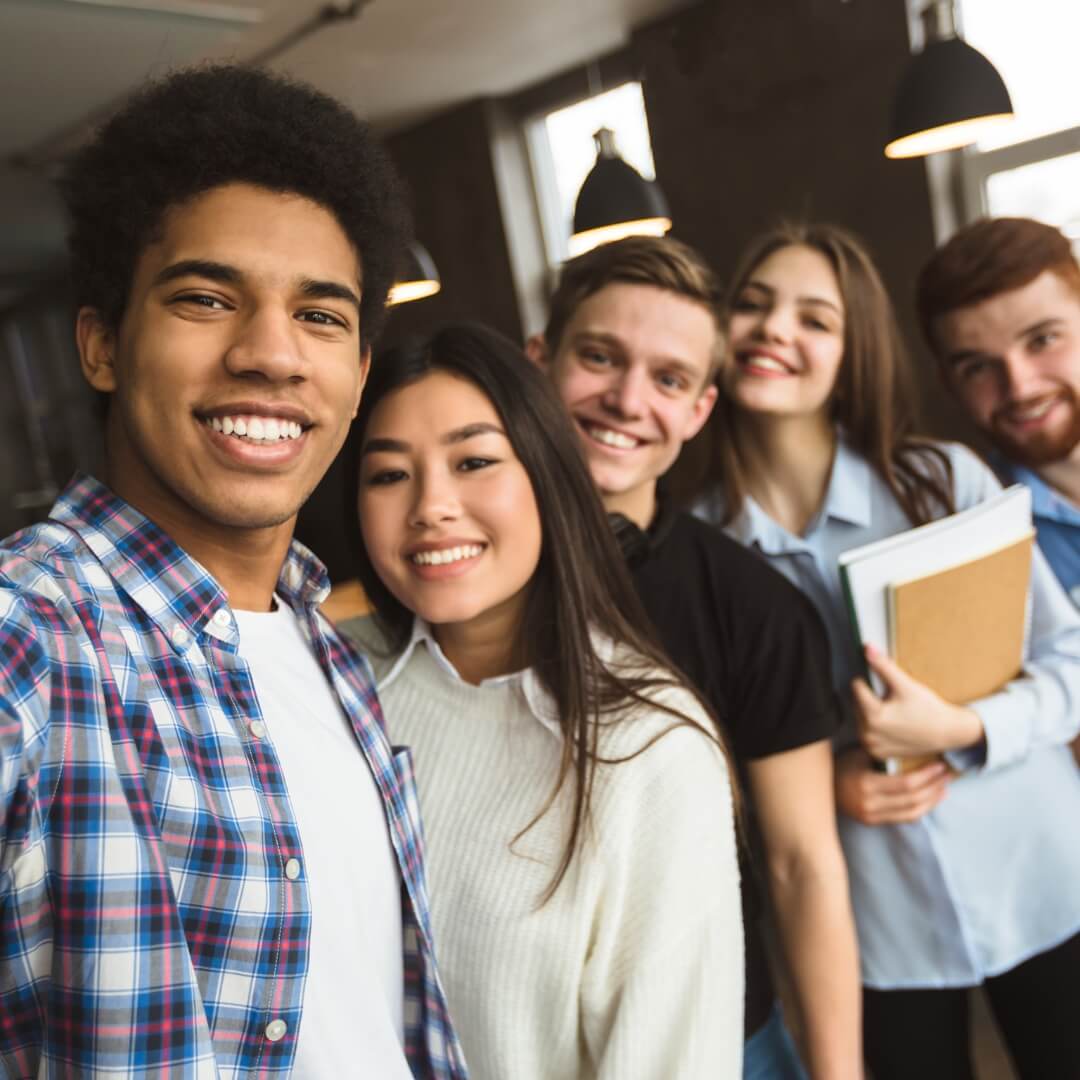 A group of young individuals smiling and posing together for a selfie